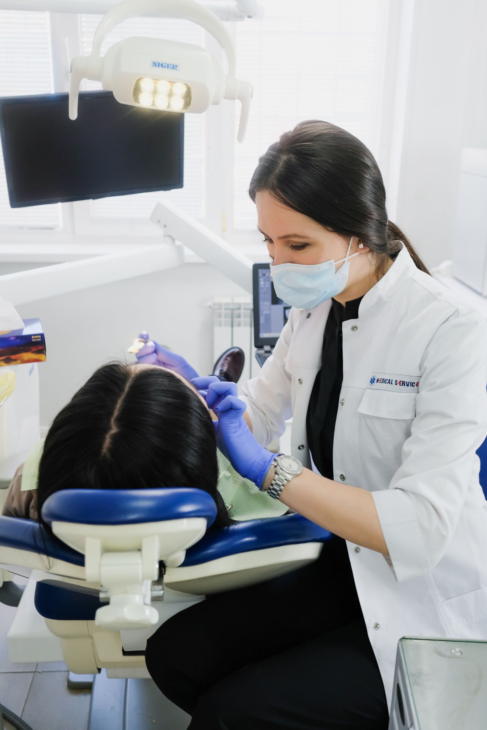 Dentista realizando exames dentários em ambiente de clínica moderna.
